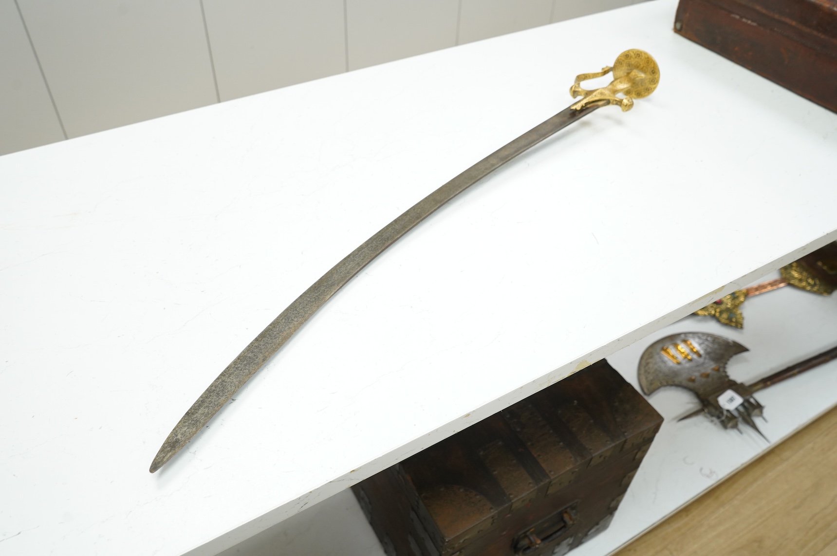 A good Indian sword tulwar, with 19th century broad curved single edge blade and iron hilt of conventional form entirely covered with flowering foliage